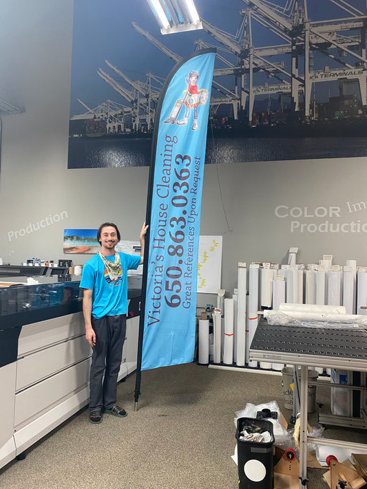 A 6ft tall person standing next to the 14ft flag, in SpeedPro Studio